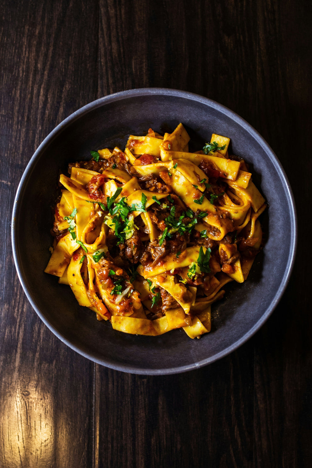 A photograph of pasta in a dark setting